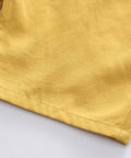 Close-up of yellow fabric on a light gray background