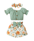 Baby outfit set with green top, floral shorts, and matching headband on a white background