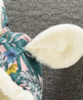 Floral-patterned slipper with white fur lining on a textured surface