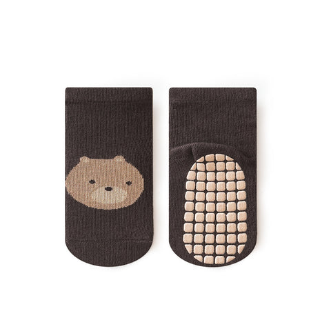 Black socks with a bear face design and textured sole on a white background