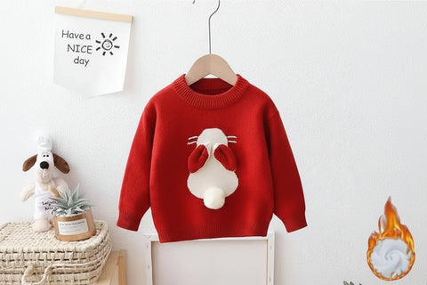 Red sweater with a cartoon dog face design on a hanger against a white wall.