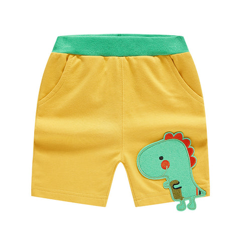 Yellow shorts with a green dinosaur patch on a white background