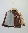 Children's jacket on a hanger against a gray curtain background