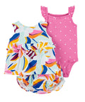 Two children's swimsuits, one colorful and one pink with white polka dots, on a white background.