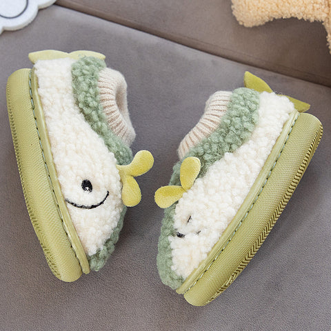 Pair of green and white baby shoes with smiling faces on a gray surface