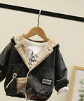denim jacket with fleece lining on a hanger against a neutral wall.
