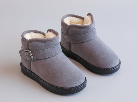 Pair of gray children's boots with fur lining on a beige surface