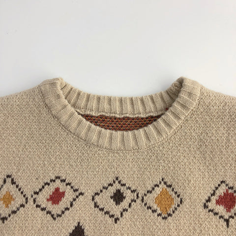 Beige sweater with diamond pattern on a white background