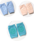 Set of baby knee pads in blue, pink, and turquoise with smiley face designs on a white background.