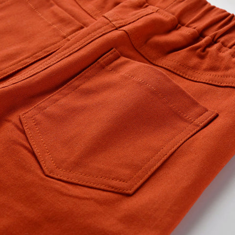 Close-up of an orange pocket on a garment with a light gray background