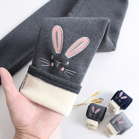 Gray leggings with bunny design held by a hand, with additional leggings in the background.