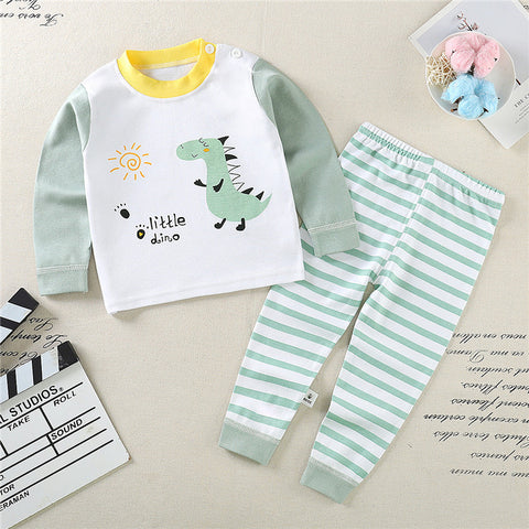 Children's outfit with dinosaur-themed shirt and striped pants on a textured surface.