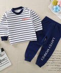 Children's outfit with striped shirt and navy pants on a beige surface