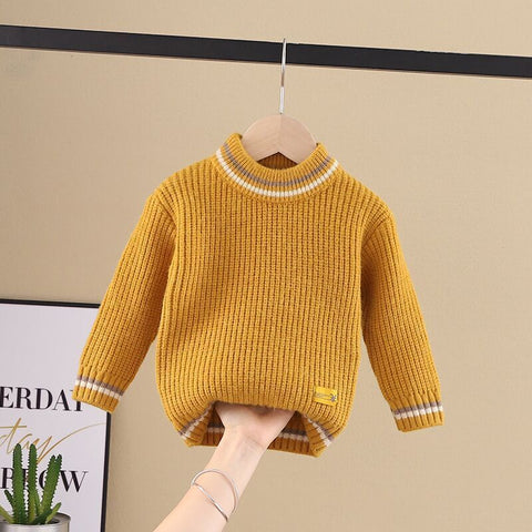 Yellow knitted sweater on a hanger against a beige background
