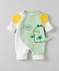 Green baby romper with dinosaur design on a gray background