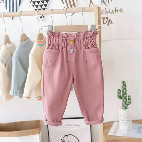 Pink children's pants on a hanger with a blurred background
