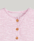 Close-up of a pink patterned shirt with buttons on a white background