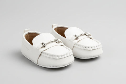 Pair of white children's loafers on a light gray background