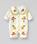 Baby romper with floral embroidery on a gray background