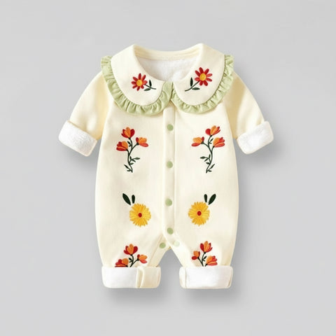 Baby romper with floral embroidery on a gray background