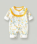 Baby onesie with yellow trim and leaf pattern on a gray background