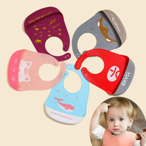 Five colorful baby bibs with different designs on a beige background, one of which is being worn by a child.