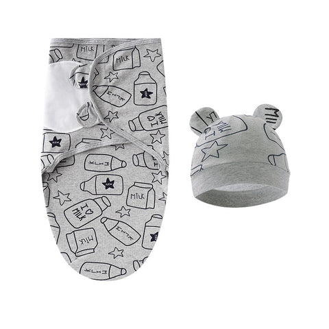 Gray baby swaddle with bottle and star pattern and matching hat on a white background