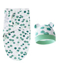 Baby swaddle and hat set with green polka dot pattern on a white background