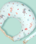 Baby boppy pillow with colorful patterns on a light green background