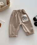 Beige baby pants with a label on a light background