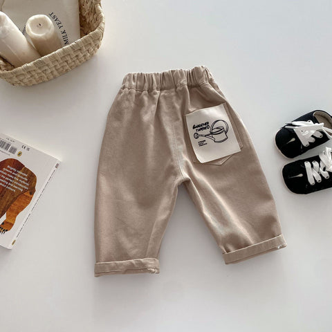Beige baby pants with a label on a light background