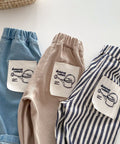 Three pairs of shorts in blue, beige, and striped pattern with branded labels on a white background.