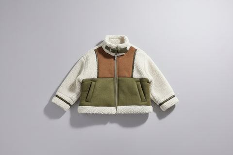 Three-tone jacket with white, brown, and green sections on a mannequin against a plain background.