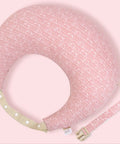 Pink baby boppy with strap on a light pink background