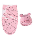 Pink baby swaddle with geometric pattern and matching hat on a white background