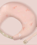 Pink neck pillow with airplane pattern on a light pink background