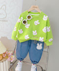 Green sweater with bunny patterns and blue jeans 