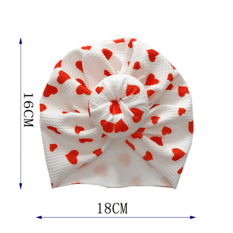 White headband with red heart patterns and measurements on a white background