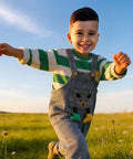Child running in a field with a clear blue sky