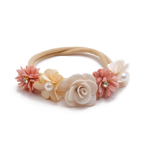 Floral headband with pink and beige flowers on a white background