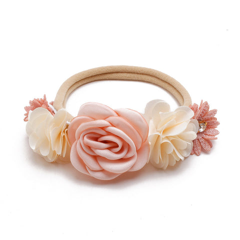 Floral headband with pink and beige flowers on a white background