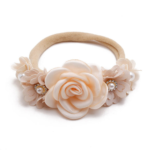 Beige floral headband with pearls on a white background