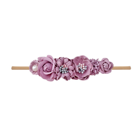 Purple floral headband with wooden stick on a white background