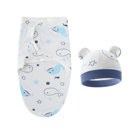 Baby swaddle with whale pattern and matching hat on a white background