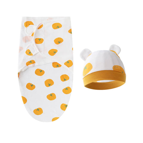 Baby swaddle with orange patterns and matching hat on a white background