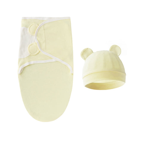 Baby swaddle and hat set in light yellow on a white background