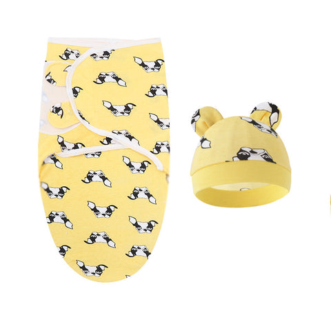 Yellow baby swaddle with black and white patterns and matching hat on a white background