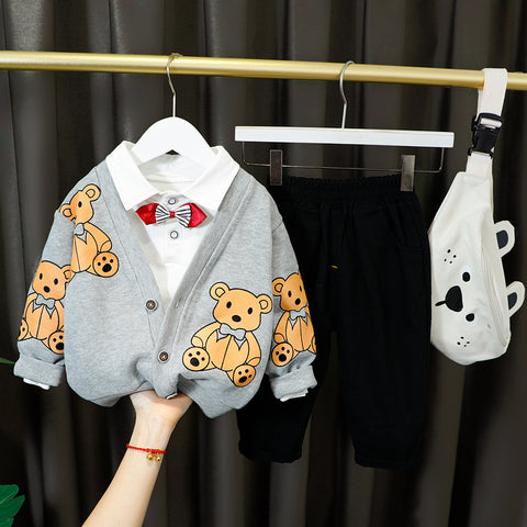 Children's clothing with teddy bear pattern on a hanger against a dark curtain background