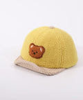Yellow children's cap with a bear emblem on a light gray background