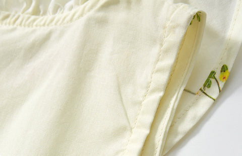 Close-up of a white fabric with floral embroidery on a light background